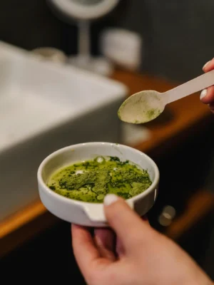 A person prepares matcha tea in a modern bathroom, capturing a calming home ritual.