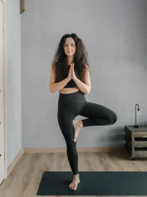 A woman practicing yoga indoors, focusing on balance and mindfulness.
