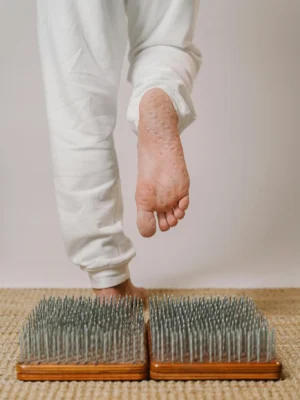 Close-up of a person practicing yoga on a nail board for foot therapy, promoting health and mindfulness.